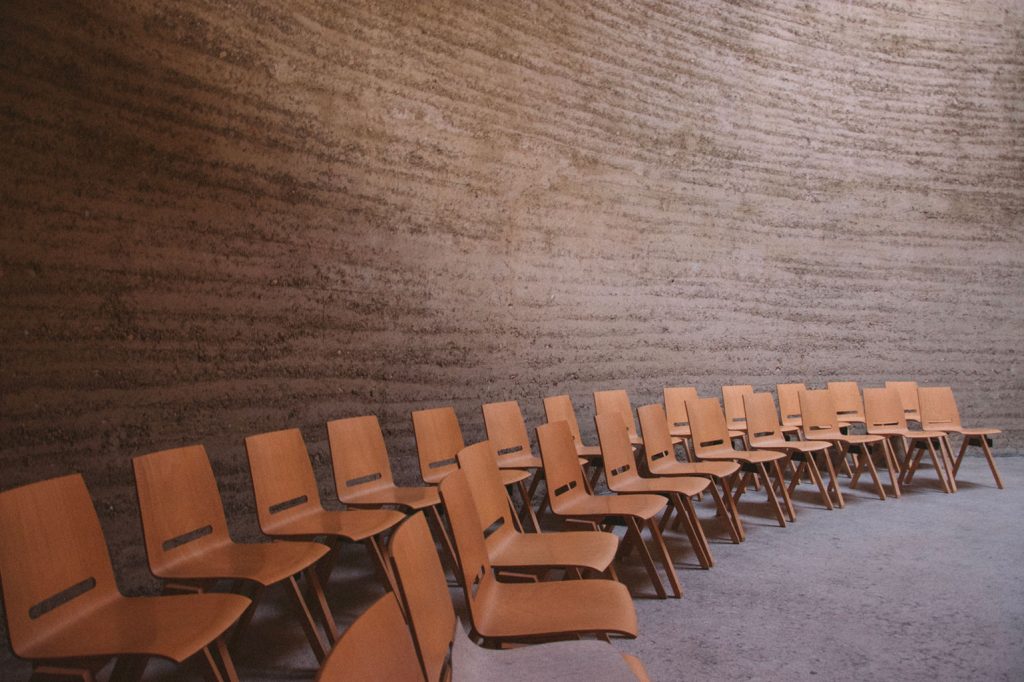 two rows of empty wooden chairs